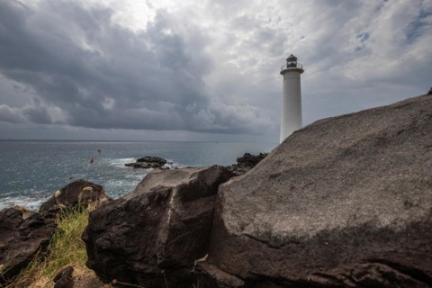 Le Phare du Vieux-Fort, white lighthouse on a cliff. Dramatic clouds with a view of the sea. Pure