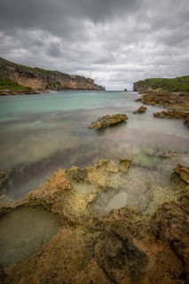 Rocky coast, long bay by the sea at sunset. Dangerous view of the Caribbean Sea. Tropical climate