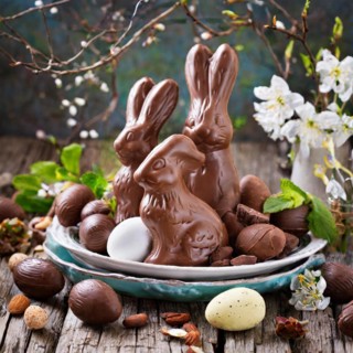 Chocolate Easter bunny with eggs and nuts on a rustic wooden table, Easter symbol, AI generated, AI