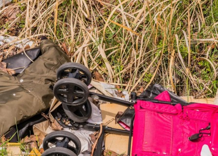 Discarded luggage and a baby stroller among debris on grass, in South Korea