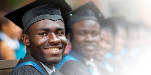 A cheerful young african american man in a blue graduation gown and cap, smiling proudly during the