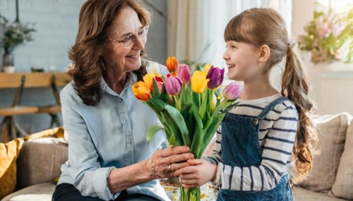 A girl happily hands a bouquet of tulips to an elderly woman, AI generated, AI generated