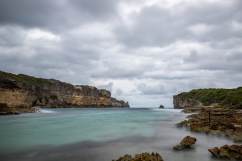 Rocky coast, long bay by the sea at sunset. Dangerous view of the Caribbean Sea. Tropical climate