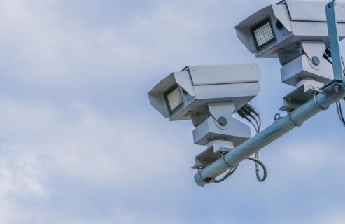 Speed radar cameras mounted on metal pole against blue sky with puffy white clouds in Daejeon,