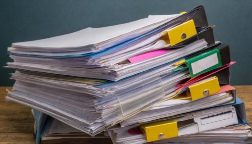 Colourful labels and clips on piles of files stand for order and office organisation, symbol