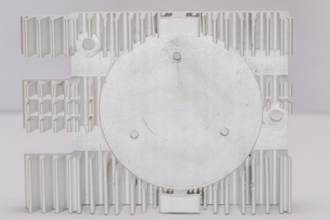 Closeup of fins and fan mounting surface of rectangle aluminum heat sink on white background