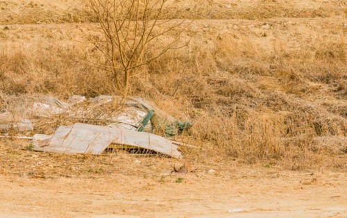 A barren landscape littered with discarded items and trash, in South Korea
