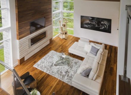 High angle view of living room with creamy beige colored L-shaped leather sofa and gas fireplace