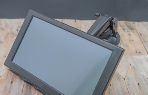 Front view of automobile navigation with attached mounting arm on wooden table with black