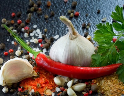 Fresh garlic arranged with red chilli, colourful peppercorns and green herbs, AI generated, AI