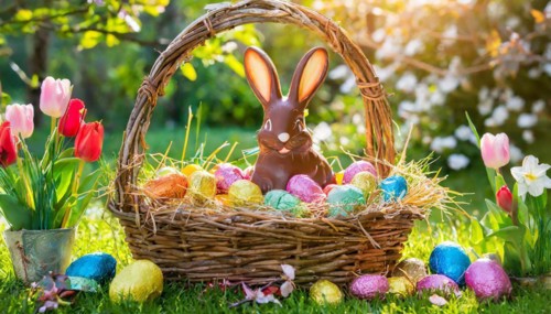 A basket with a chocolate Easter bunny and coloured eggs, surrounded by nature, symbol Easter, AI