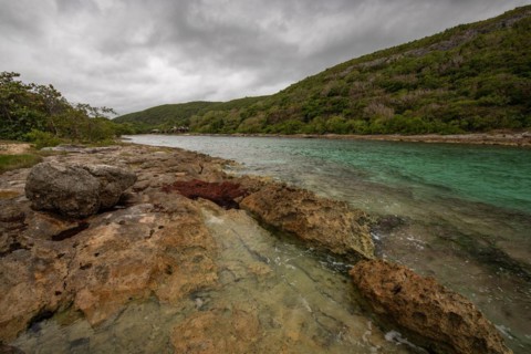 Rocky coast, long bay by the sea at sunset. Dangerous view of the Caribbean Sea. Tropical climate