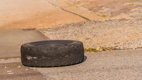 A used tire with drawings left on urban pavement, portraying a waste disposal issue, in South Korea