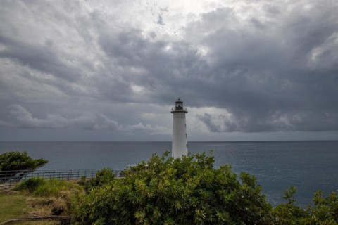 Le Phare du Vieux-Fort, white lighthouse on a cliff. Dramatic clouds with a view of the sea. Pure