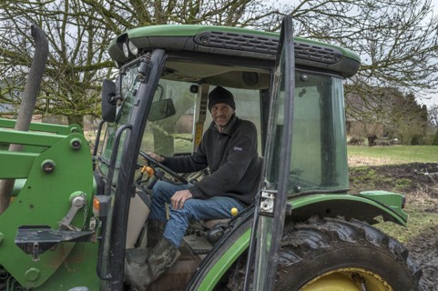 Young farmer in the tractor cab on his farm, Othenstorf, Mecklenburg-Vorpommern, Germany, Europe