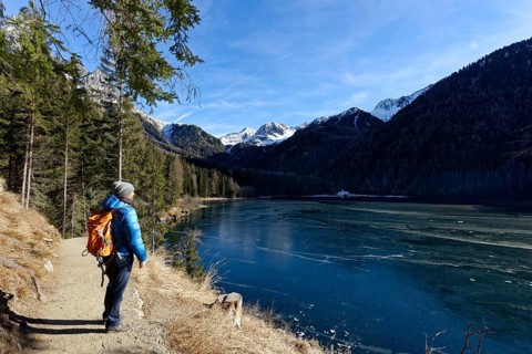 Hikers in winter on an icy lake, Lake Antholz in the Antholz Valley, Val Pusteria, South Tyrol,