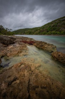 Rocky coast, long bay by the sea at sunset. Dangerous view of the Caribbean Sea. Tropical climate