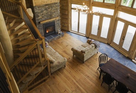 High angle view of wooden and black wrought iron staircase and living room and dining table inside