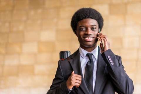 Frontal close-up portrait with copy space of a young happy architect with afro hairstyle and suit