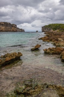 Rocky coast, long bay by the sea at sunset. Dangerous view of the Caribbean Sea. Tropical climate