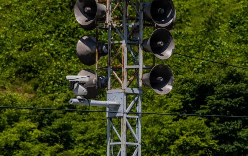 Communication tower consisting of loud speakers, solar panel and closed circuit camera with tree