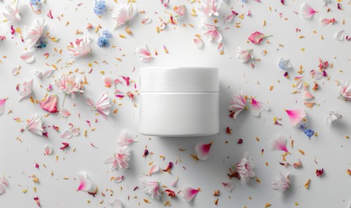 Blank creme jar mockup with scattered flower petals on a white background, beauty in nature AI