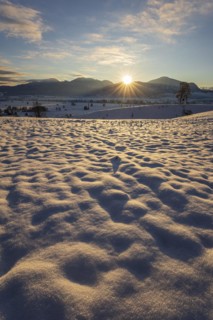 Sunrise over mountains in winter, snow, backlight, sunbeams, Alpine foothills, view of