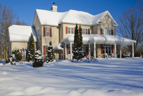 Two story beige vinyl siding with brownish red nuanced brick veneer and orange trim home in winter,
