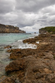 Rocky coast, long bay by the sea at sunset. Dangerous view of the Caribbean Sea. Tropical climate
