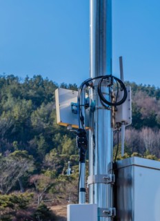 Closeup of coaxial cables from outdoor wireless router secured to meal pole using electrical tape
