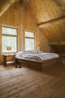 King size bed with wooden frame in master bedroom on upstairs floor inside handcrafted Eastern