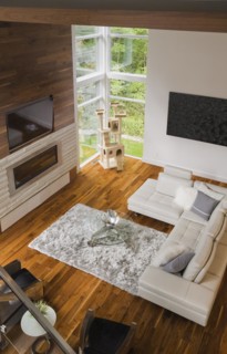 High angle view of living room with creamy beige colored L-shaped leather sofa and gas fireplace