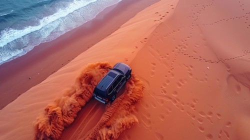 A 4x4 carving deep tracks in a sand dune near the coastline with moody skies, action sports