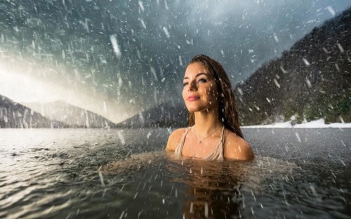 A young pretty woman bathes in an ice-cold lake in snowfall, AI generated, AI generated