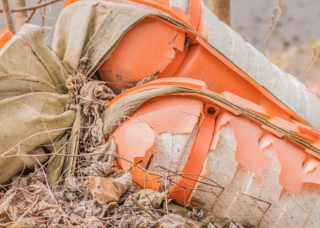 Discarded broken river floats entangled with burlap on dry vegetation, in South Korea
