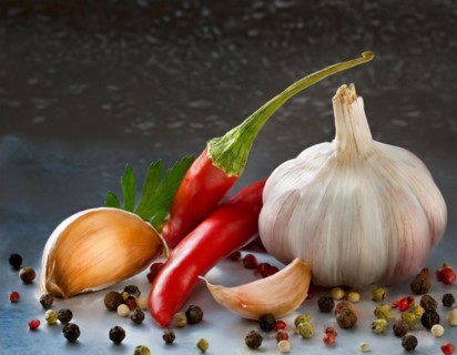 Fresh garlic arranged with red chilli, colourful peppercorns and green herbs, AI generated, AI