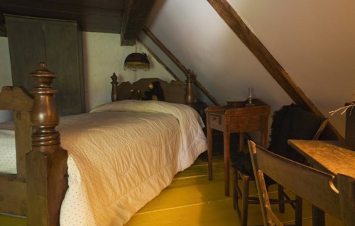Antique wooden four-poster single bed and armoire in bedroom on upstairs floor inside old 1785