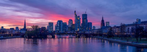 The Frankfurt skyline with office tower blocks behind the Main at sunset, on the left the