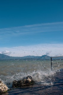 Splashing waves hitting rocks on the shore of Lake Garda, Sirmione, Lake Garda, Italy, Europe