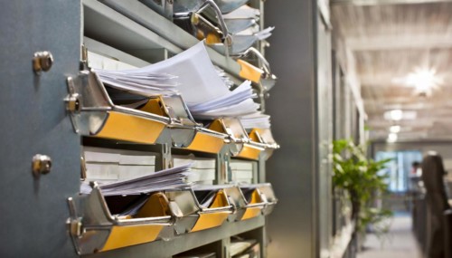 Wall mount with pockets full of documents and folders in an office, symbol bureaucracy, AI