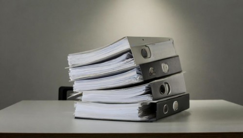 Stacks of black folders with many pages on a desk, symbolism bureaucracy, AI generated, AI