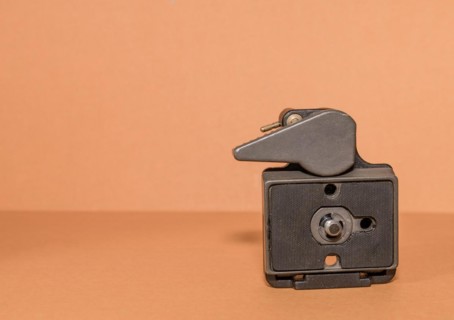 Closeup top view of quick release tripod head on brown background