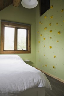 Child's bedroom with climbing wall on upstairs floor inside contemporary style log home, Quebec,