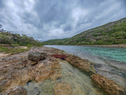 Rocky coast, long bay by the sea at sunset. Dangerous view of the Caribbean Sea. Tropical climate