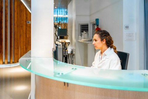 Side view photo with copy space of a female healthcare worker in the reception of an ophthalmology