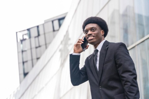 Low angle view close-up portrait with copy space of a Young african businessman using phone in the