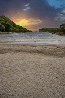 Rocky coast, long bay by the sea at sunset. Dangerous view of the Caribbean Sea. Tropical climate