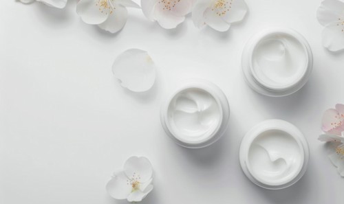Three creme jar blank mockups nestled amidst delicate flower petals on a white background AI