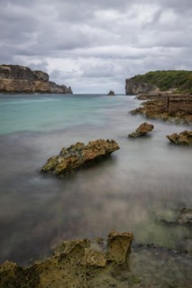 Rocky coast, long bay by the sea at sunset. Dangerous view of the Caribbean Sea. Tropical climate