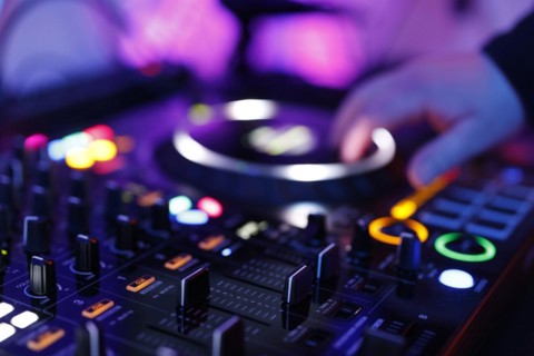 Hand of a DJ on a mixing desk, also called DJ controller or DJ console, at a party, Cologne, North